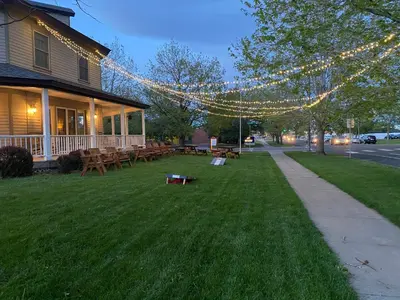 a yard with picnic tables and strings of lights at The Currier Inn in Greeley