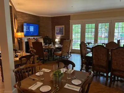 a dining room with tables and chairs and a television at The Currier Inn in Greeley