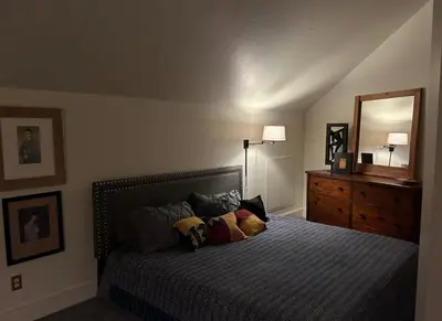 a bedroom with a bed with pillows and a mirror at The Currier Inn in Greeley