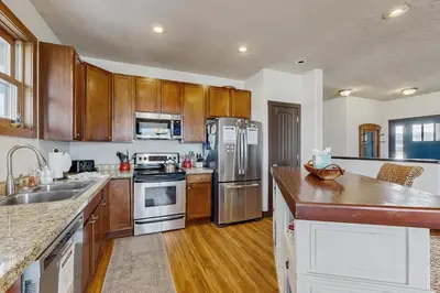 a kitchen with wooden cabinets and stainless steel appliances at Silver Sage Sanctuary in Granby