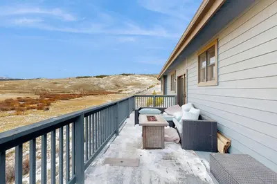 a balcony with a couch and a table on a house at Silver Sage Sanctuary in Granby