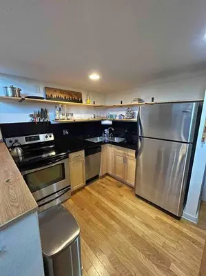 a kitchen with a stainless steel refrigerator and wooden floors at Affordable & Chic RiNo/LoDo/Dtown Loft- Walkable in Denver