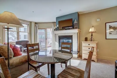 a living room with a table and a fireplace at 8179 Silver Mill condo in Keystone