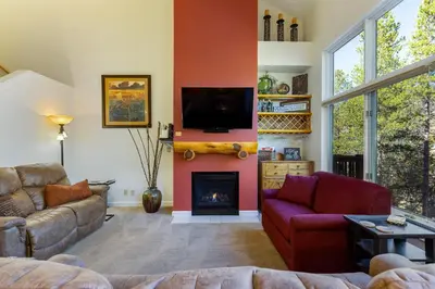 a living room with a fireplace and a tv at 1849 The Seasons townhouse in Keystone