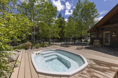 a hot tub sitting on a deck next to a house at 1849 The Seasons townhouse in Keystone
