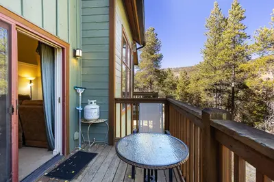 a wooden balcony with a table and chairs on it at 1849 The Seasons townhouse in Keystone