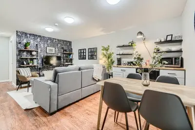a living room with a couch and a table at Adorable 2-Bedroom Modern Basement in Denver