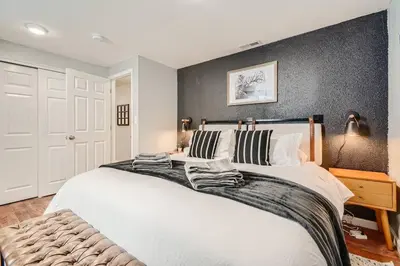 a bedroom with a large white bed with two pillows at Adorable 2-Bedroom Modern Basement in Denver