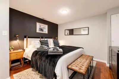 a bedroom with a large bed with a black wall at Adorable 2-Bedroom Modern Basement in Denver