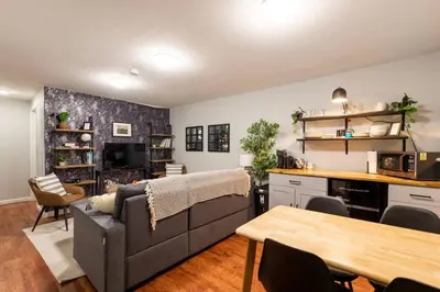 a living room with a couch and a table at Adorable 2-Bedroom Modern Basement in Denver