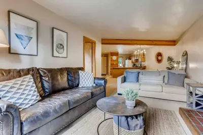 a living room with a leather couch and a table at Cozy Ski Condo + Hot Tub + Fireplace + Heated Pool in Silverthorne