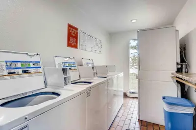 a white laundry room with a row of white appliances at Cozy Ski Condo + Hot Tub + Fireplace + Heated Pool in Silverthorne