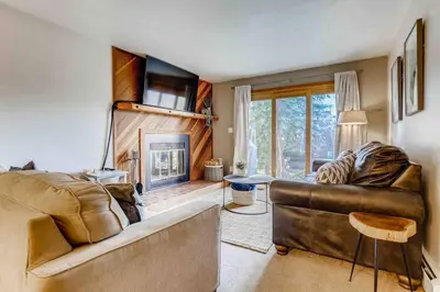 a living room with a couch and a fireplace at Cozy Ski Condo + Hot Tub + Fireplace + Heated Pool in Silverthorne