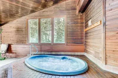 a large blue tub in a room with wooden walls at Cozy Ski Condo + Hot Tub + Fireplace + Heated Pool in Silverthorne