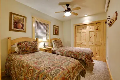 a bedroom with two beds and a ceiling fan at half Mi to Granby Ranch Townhome with Fireplace! in Granby