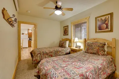 a bedroom with two beds and a ceiling fan at half Mi to Granby Ranch Townhome with Fireplace! in Granby