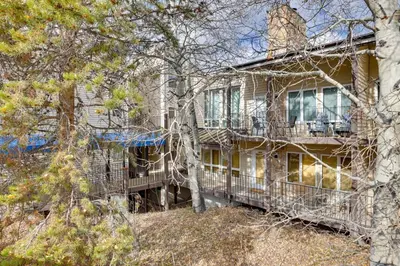 a large house with a balcony and trees at half Mi to Granby Ranch Townhome with Fireplace! in Granby