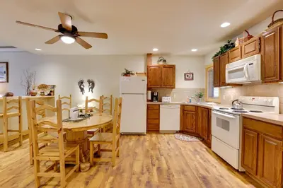 a kitchen with a table and a white refrigerator at half Mi to Granby Ranch Townhome with Fireplace! in Granby