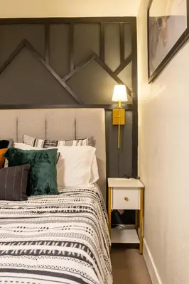 a bedroom with a large bed and a lamp on a table at Rocky Mountain Haven-Modern 2BD, 1BA Basement Retreat in Lakewood in Lakewood