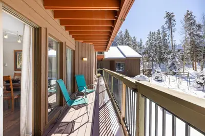 a balcony with two chairs and a table on a house at 1076 Wild Irishman condo in Keystone