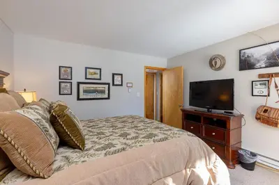 a bedroom with a bed and a flat screen tv at 1076 Wild Irishman condo in Keystone
