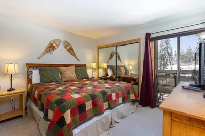 a bedroom with a bed and a sliding glass door at 1076 Wild Irishman condo in Keystone