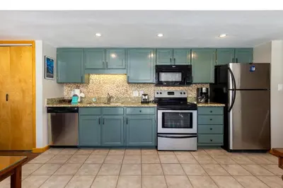 a kitchen with blue cabinets and stainless steel appliances at 1076 Wild Irishman condo in Keystone