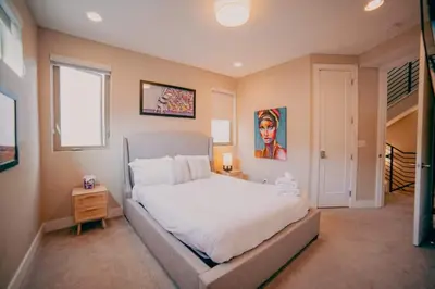 a bedroom with a large white bed and a window at Golden Triangle Townhome at Downtown Denver in Denver