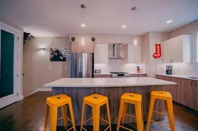 a kitchen with three yellow stools at a counter at Golden Triangle Townhome at Downtown Denver in Denver