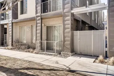 a sidewalk in front of a building with a fence at Golden Triangle Townhome at Downtown Denver in Denver