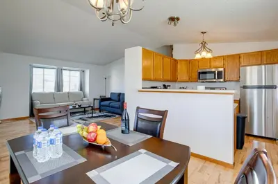a kitchen and living room with a table and a refrigerator at Patio, Grill, Yard Pet-Friendly Denver Home! in Aurora