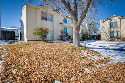 a house with a tree and a pile of leaves at Patio, Grill, Yard Pet-Friendly Denver Home! in Aurora