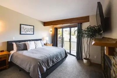 a bedroom with a bed and a sliding glass door at Winter Park Townhome with Hot Tub, Half Mi to Dtwn! in Winter Park