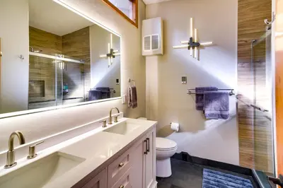a bathroom with a sink and a toilet and a mirror at Winter Park Townhome with Hot Tub, Half Mi to Dtwn! in Winter Park