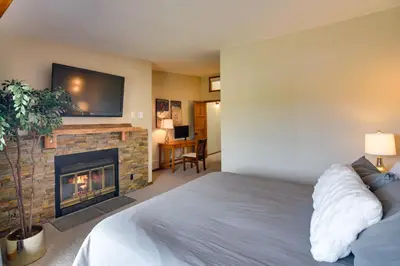 a bedroom with a bed and a fireplace at Winter Park Townhome with Hot Tub, Half Mi to Dtwn! in Winter Park