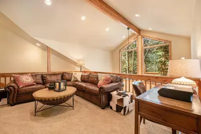 a living room with a leather couch and a table at Fall River Retreat - Monthly Long-Term Vacation Rental townhouse in Estes Park