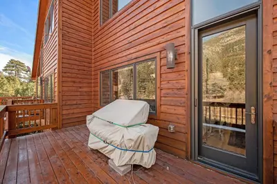 a porch with a mattress on the side of a house at Fall River Retreat - Monthly Long-Term Vacation Rental townhouse in Estes Park