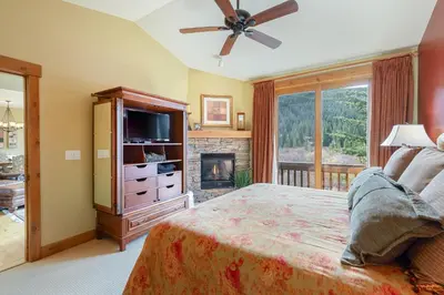 a bedroom with a bed with a television and a fireplace at 66 Thackwell Lane townhouse in Keystone