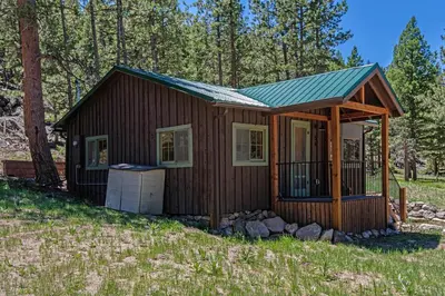 a cabin in the woods with a gambrel roof at Niwot Cabin - Stay in Rocky Mountain National Park - Estes Park - NEW LISTING - 22-ZONE3298 cabin in Estes Park