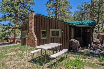 a picnic table in front of a tiny house at Niwot Cabin - Stay in Rocky Mountain National Park - Estes Park - NEW LISTING - 22-ZONE3298 cabin in Estes Park