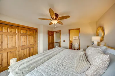 a bedroom with a large bed with a ceiling fan at 6 Mi to Winter Park Resort Townhome with Hot Tub! in Fraser