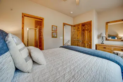 a bedroom with a large bed and a mirror at 6 Mi to Winter Park Resort Townhome with Hot Tub! in Fraser
