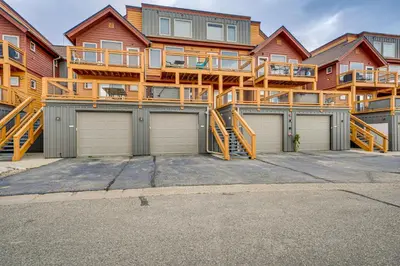 a large apartment building with three garage doors at 6 Mi to Winter Park Resort Townhome with Hot Tub! in Fraser