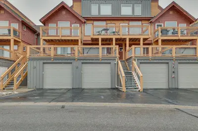 a house with two garage doors in front of it at 6 Mi to Winter Park Resort Townhome with Hot Tub! in Fraser