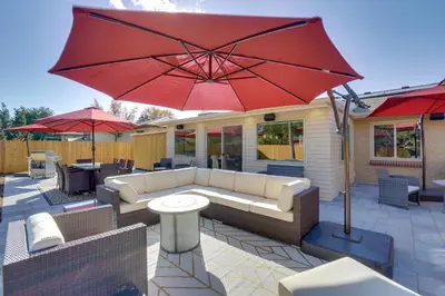 a patio with a couch and a red umbrella at Private Hot Tub and Sauna Saulsbury Guest House in Wheat Ridge