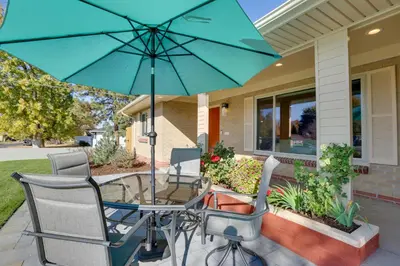 a patio table with a blue umbrella in front of a house at Private Hot Tub and Sauna Saulsbury Guest House in Wheat Ridge