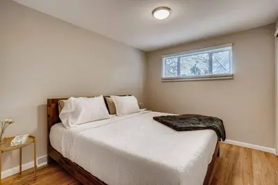 a bedroom with a large white bed with a window at Close to Denver & Golden - Perfect for Groups in Arvada