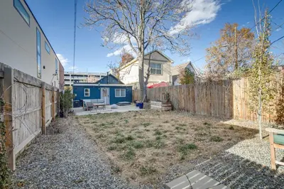a backyard with a fence and a blue house at Cozy and Pet-Friendly Home - 3 Mi to Downtown Denver in Denver