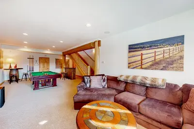 a living room with a couch and a pool table at Sundance Mountain Retreat in Fraser