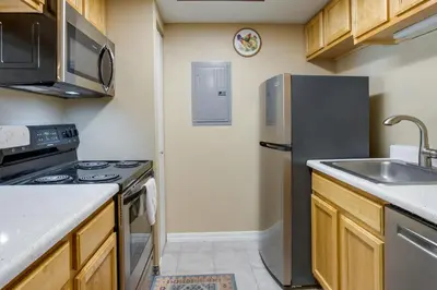a kitchen with a stainless steel refrigerator and a sink at 1 Mi to Light Rail Englewood Condo with Pool Access in Englewood